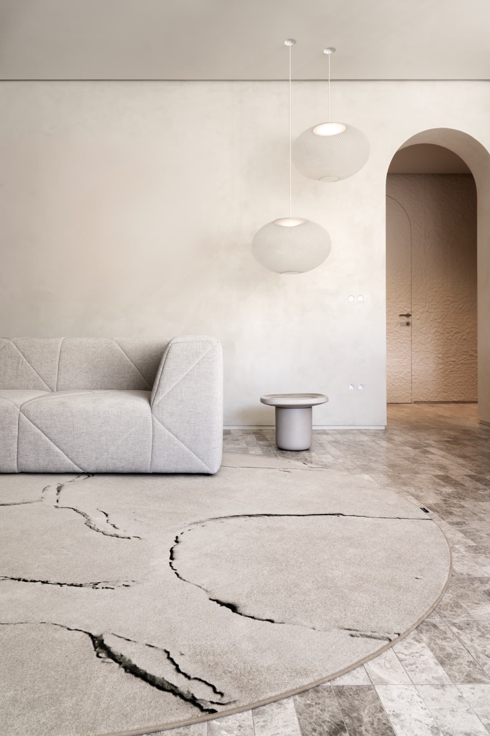 Living space with pendant lights and organic rug